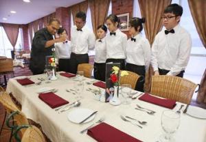 Students being briefed by KDU Penang School of Hospitality, Tourism and Culinary Arts programme leader Prakash R. Jakathesan on the art of table settings. 